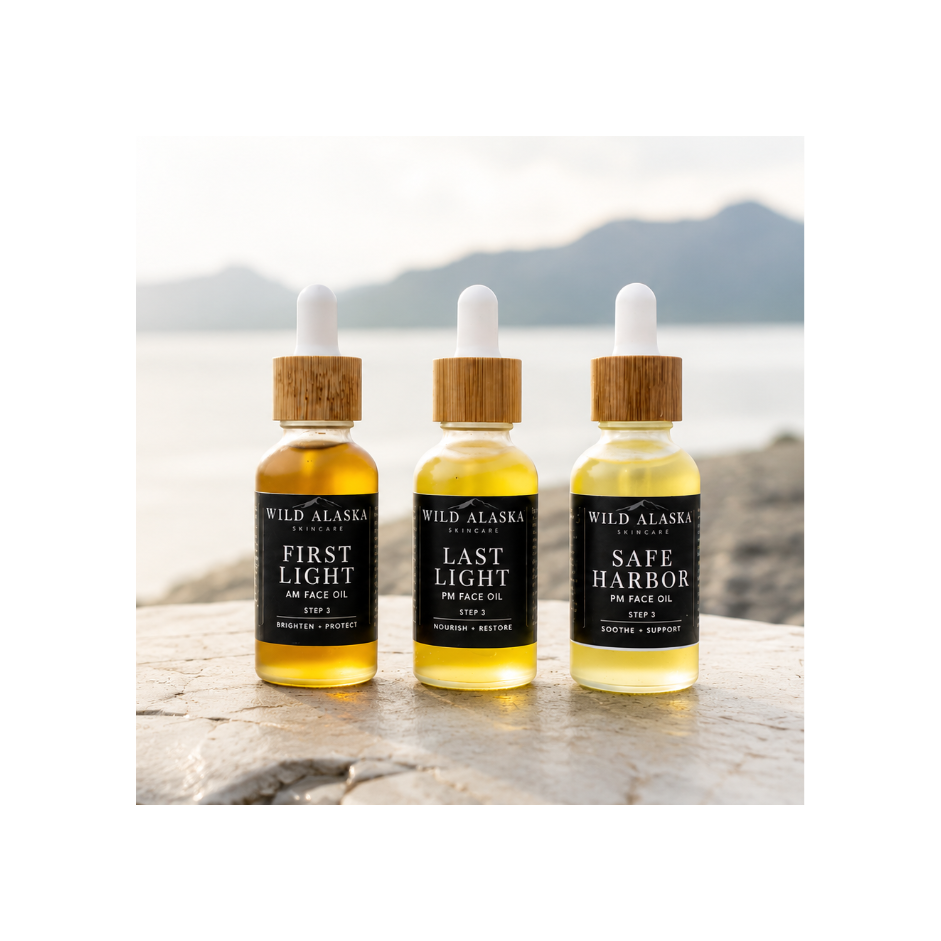 Three bottles of Wild Alaska Spirits on a rocky surface with a scenic background