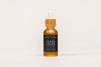 Bottle of Wild Alaska Naturals First Light skin and face oil on a white background
