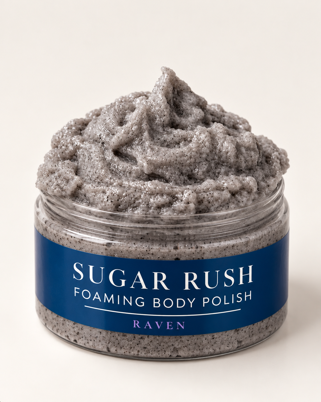 Open jar of Sugar Rush Foaming Body Polish in Raven showing its dark gray whipped, texture.