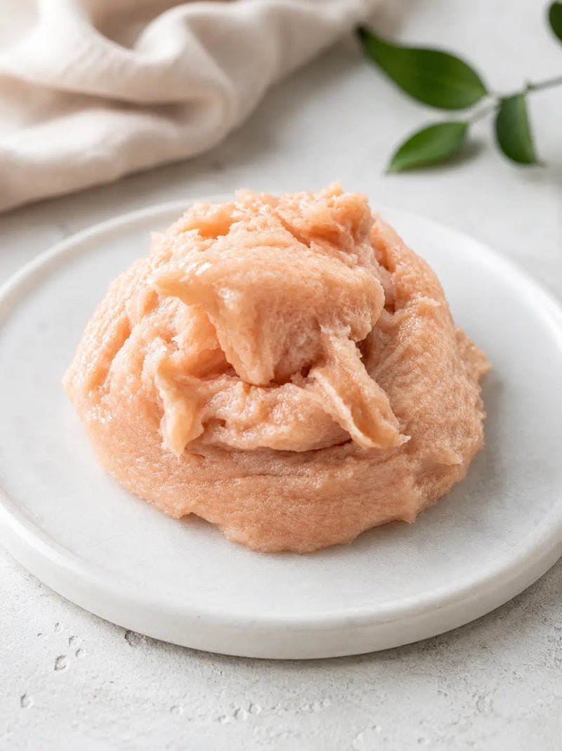 Pinkish sugar scrub on a white plate with a light background